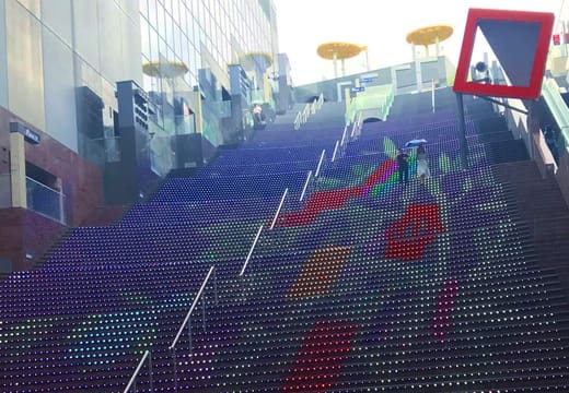 The grand staircase of Kyoto Station Building lit with coloured lights