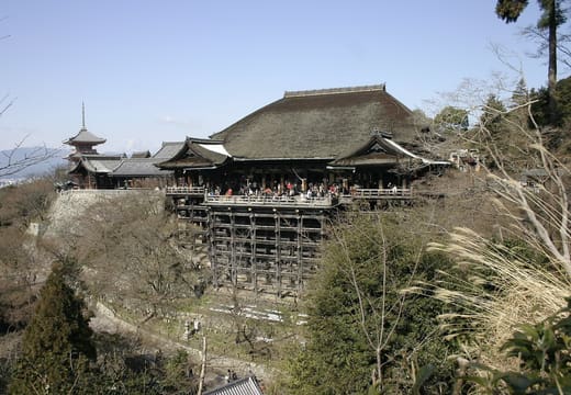 The main hall of Kiyomizu-dera on its wooden stage above the wooded hillside