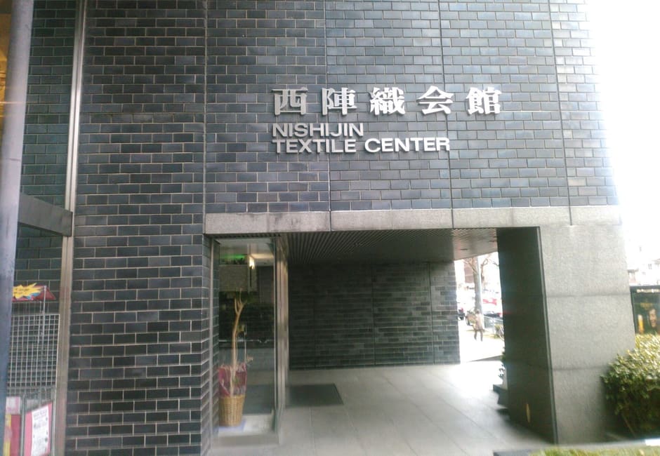 The dark tiled entrance of the Nishijin Textile Center building in Kyoto