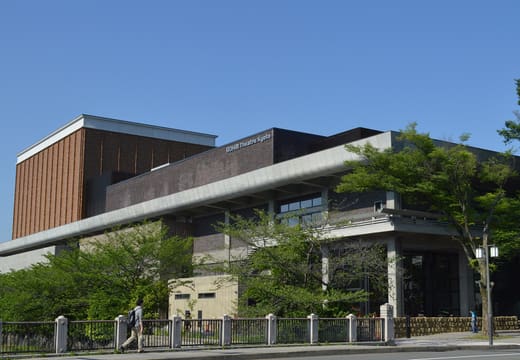 The modernist exterior of ROHM Theatre Kyoto in Okazaki under a clear blue sky