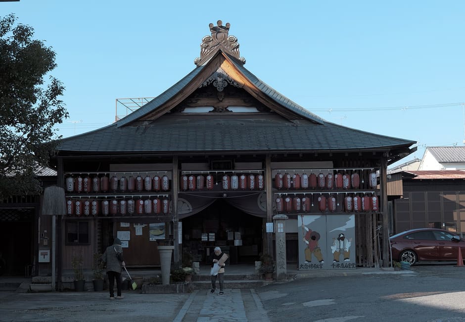 The main hall of Senbon Enma-do, its front hung with rows of red and white lanterns above the stone forecourt
