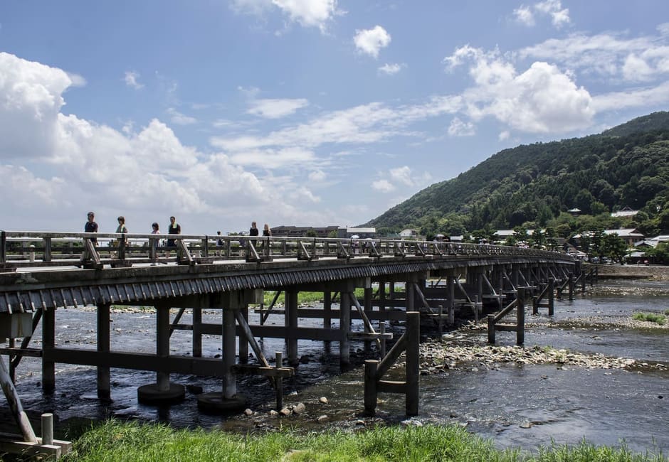 The wooden Togetsukyo bridge across the river with the Arashiyama hills behind