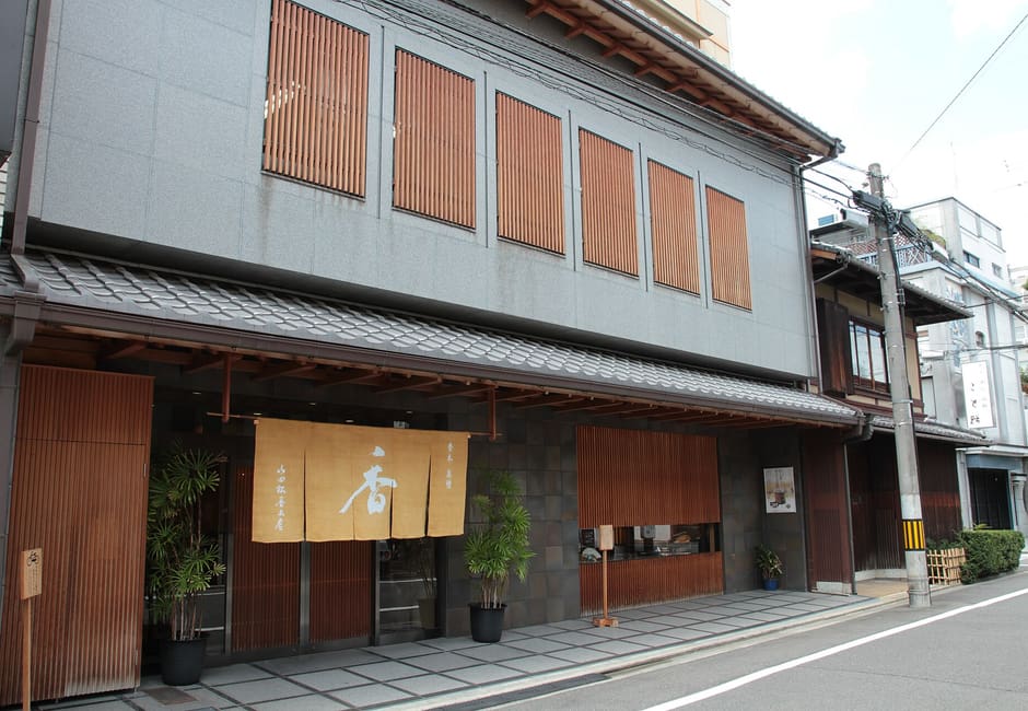 The front of the Yamadamatsu Kobokuten incense shop, with a noren marked with the character for incense